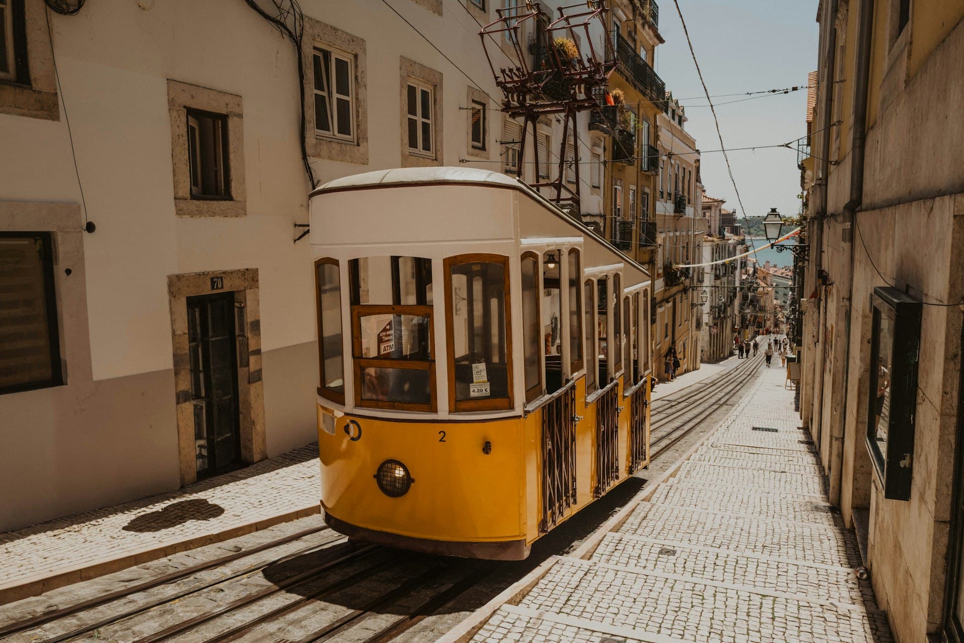 A yellow tram on a cobbled street in Lisbon, Portugal